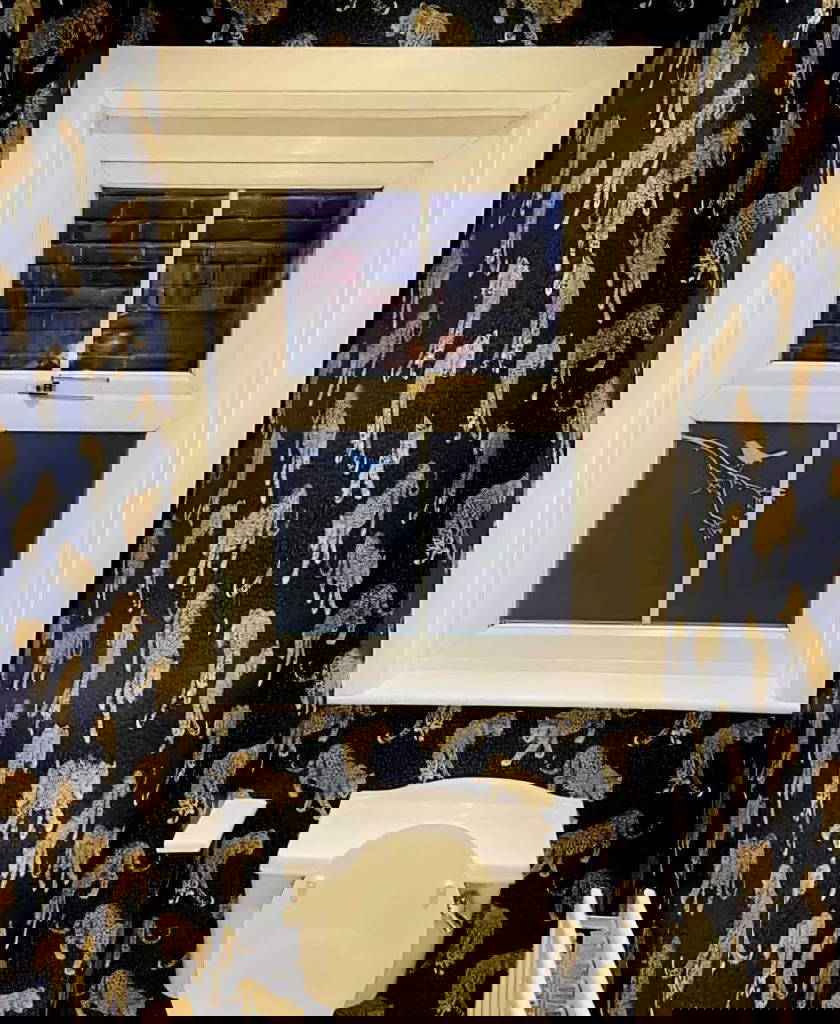 An image of interior work done by Gloss 'n' Gardens. This bathroom is done with new wallpaper, and new paint on the windows.