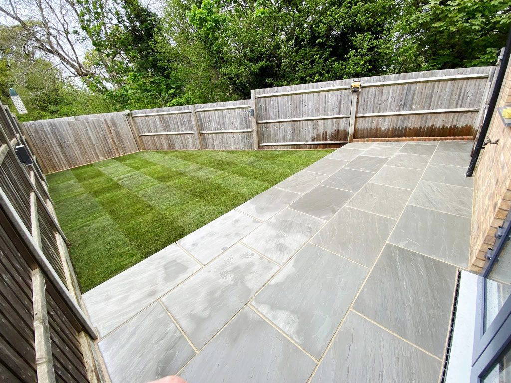 An image of Gloss 'n' Gardens work, done on a client's yard. The yard has new sod laid and a new stone patio.